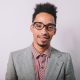 Happy elegant joyful guy in grey jacket and shirt wears glasses looking at camera, smiling  on the background of white background, successful businessman, cheerful mood, work, meeting
